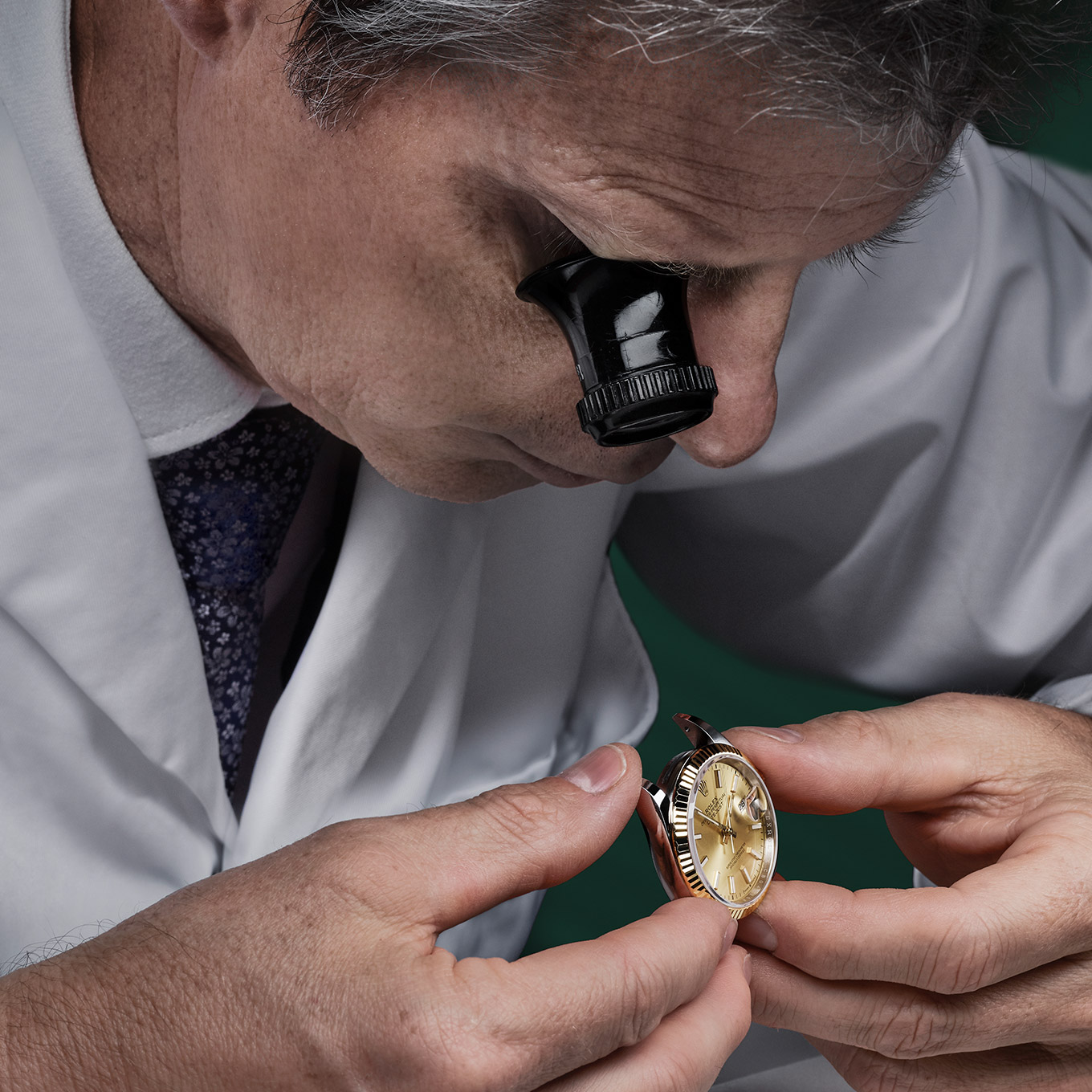 Ein Uhrmacher untersucht sorgfältig die zur Wartung gegebene Rolex Uhr